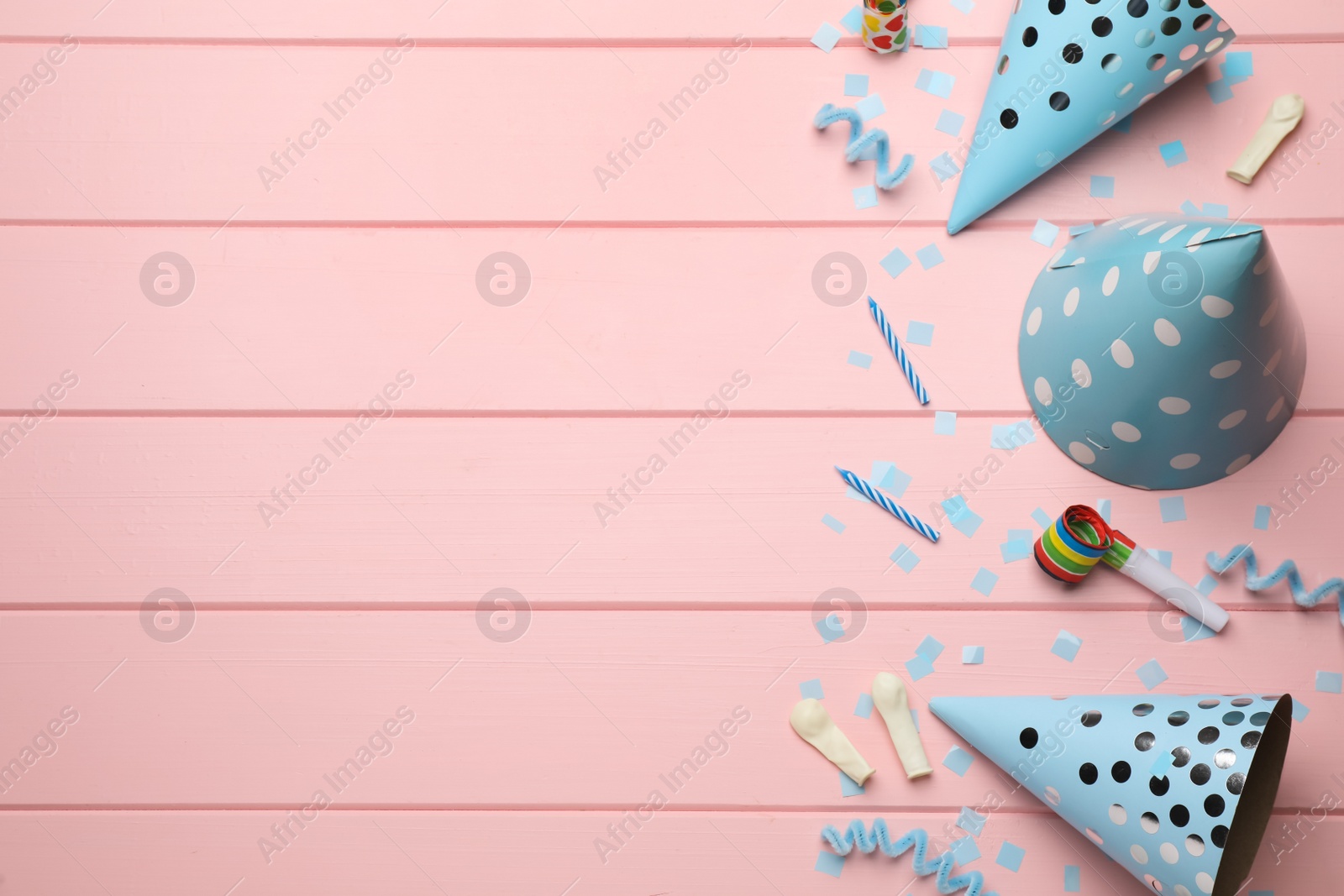 Photo of Flat lay composition with party items on pink wooden table, space for text