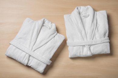 Photo of Flat lay composition with folded bathrobes on wooden background