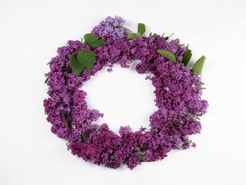 Photo of Wreath made of beautiful lilac flowers and green leaves on white background, top view