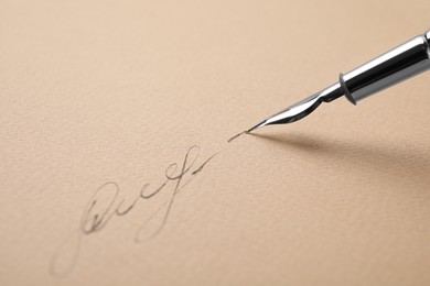 Photo of Signing on sheet of paper with fountain pen, closeup. Space for text