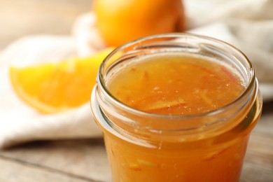 Photo of Homemade delicious orange jam on table, closeup view
