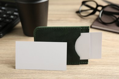 Photo of Leather business card holder with blank cards on wooden table