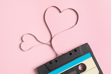 Photo of Music cassette and hearts made with tape on pink background, top view. Listening love song