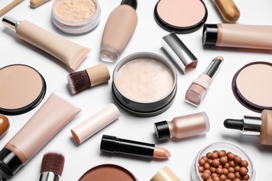Photo of Face powders and other makeup products on white background, closeup