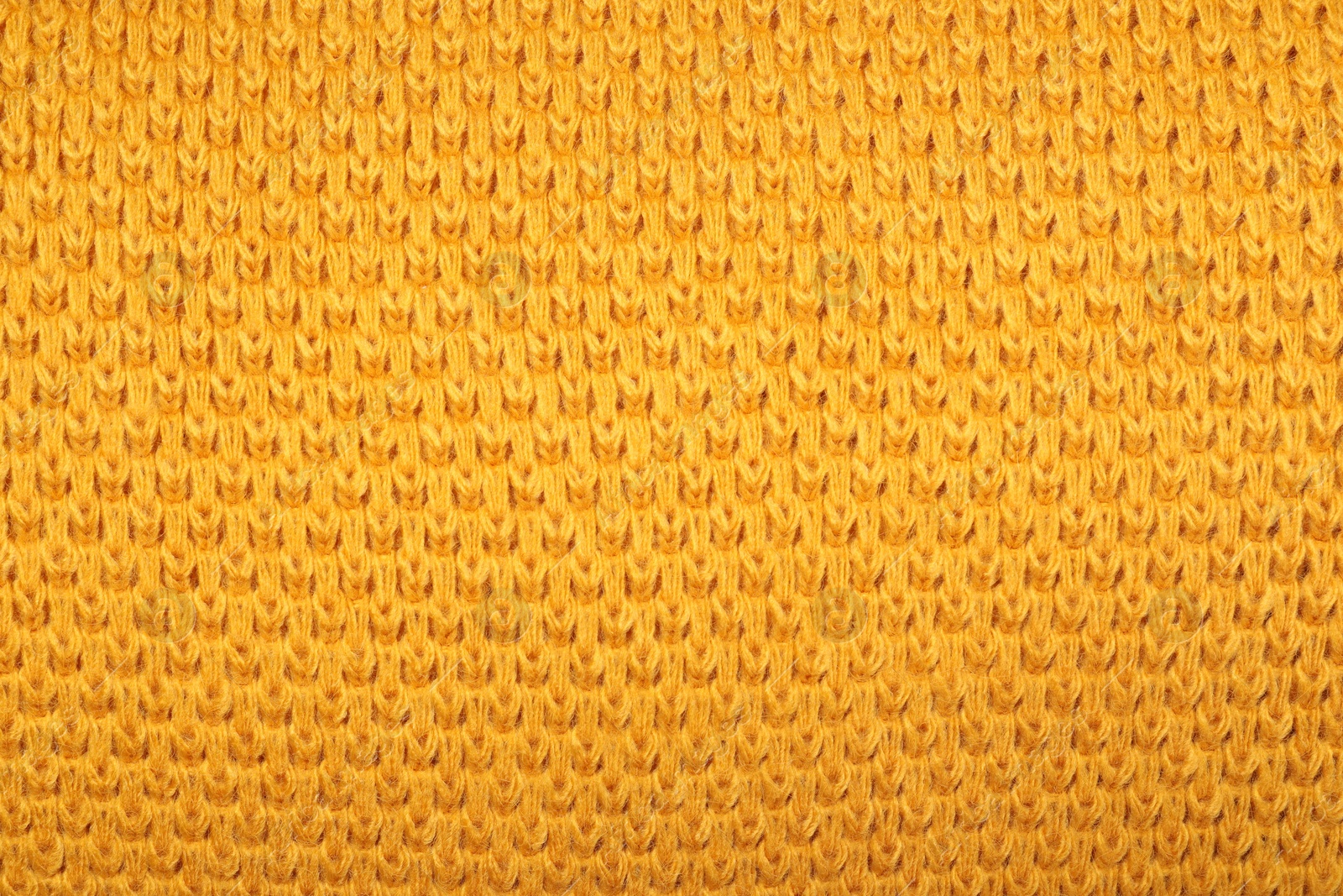 Photo of Texture of yellow knitted blanket as background, closeup