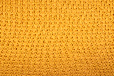 Texture of yellow knitted blanket as background, closeup