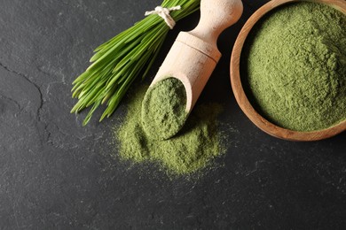 Photo of Wheat grass powder and fresh sprouts on grey textured table, flat lay