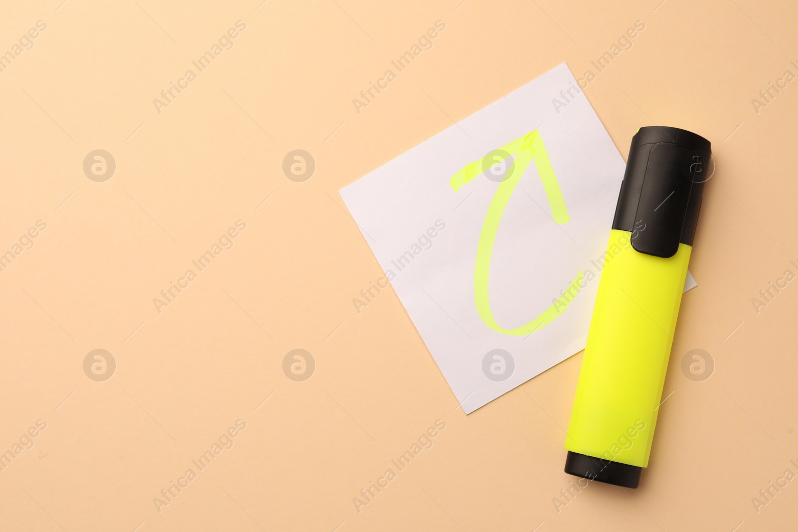 Photo of Bright yellow marker and sticky note with drawn arrow on beige background, flat lay. Space for text
