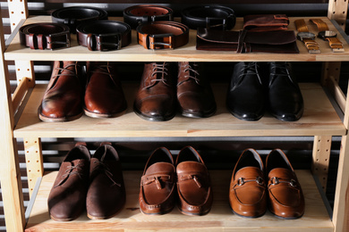 Wooden shelving unit with different leather shoes and belts