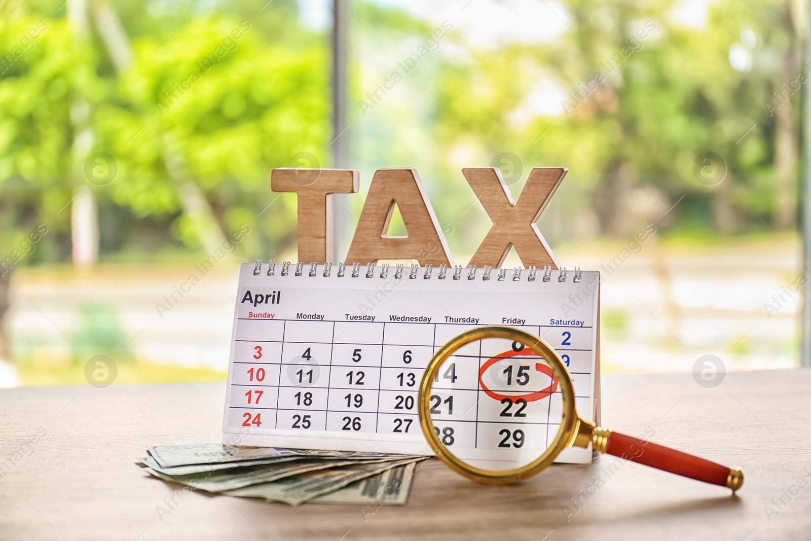 Photo of Word TAX, calendar, magnifier and money on table