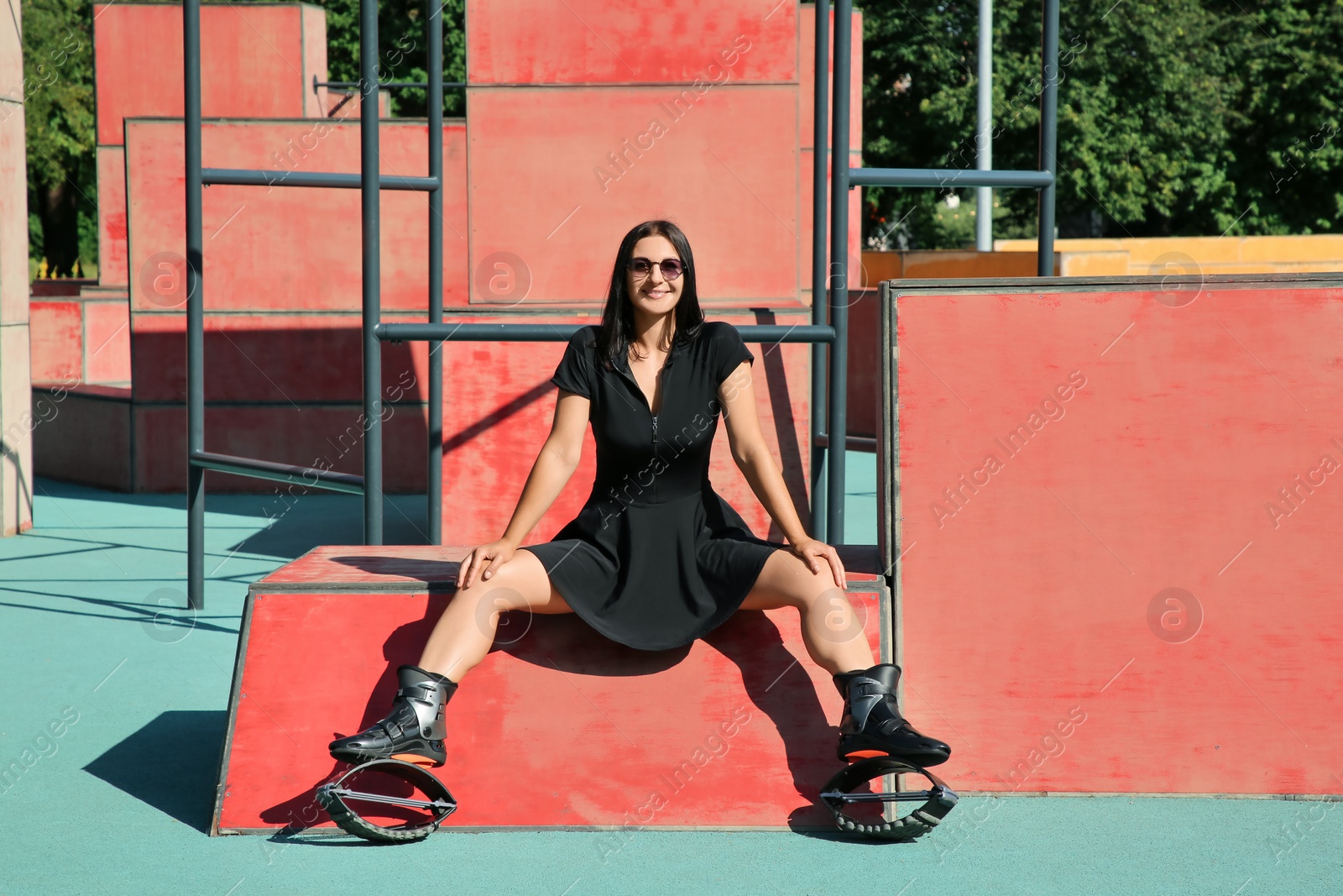 Photo of Woman with kangoo jumping boots sitting in workout park