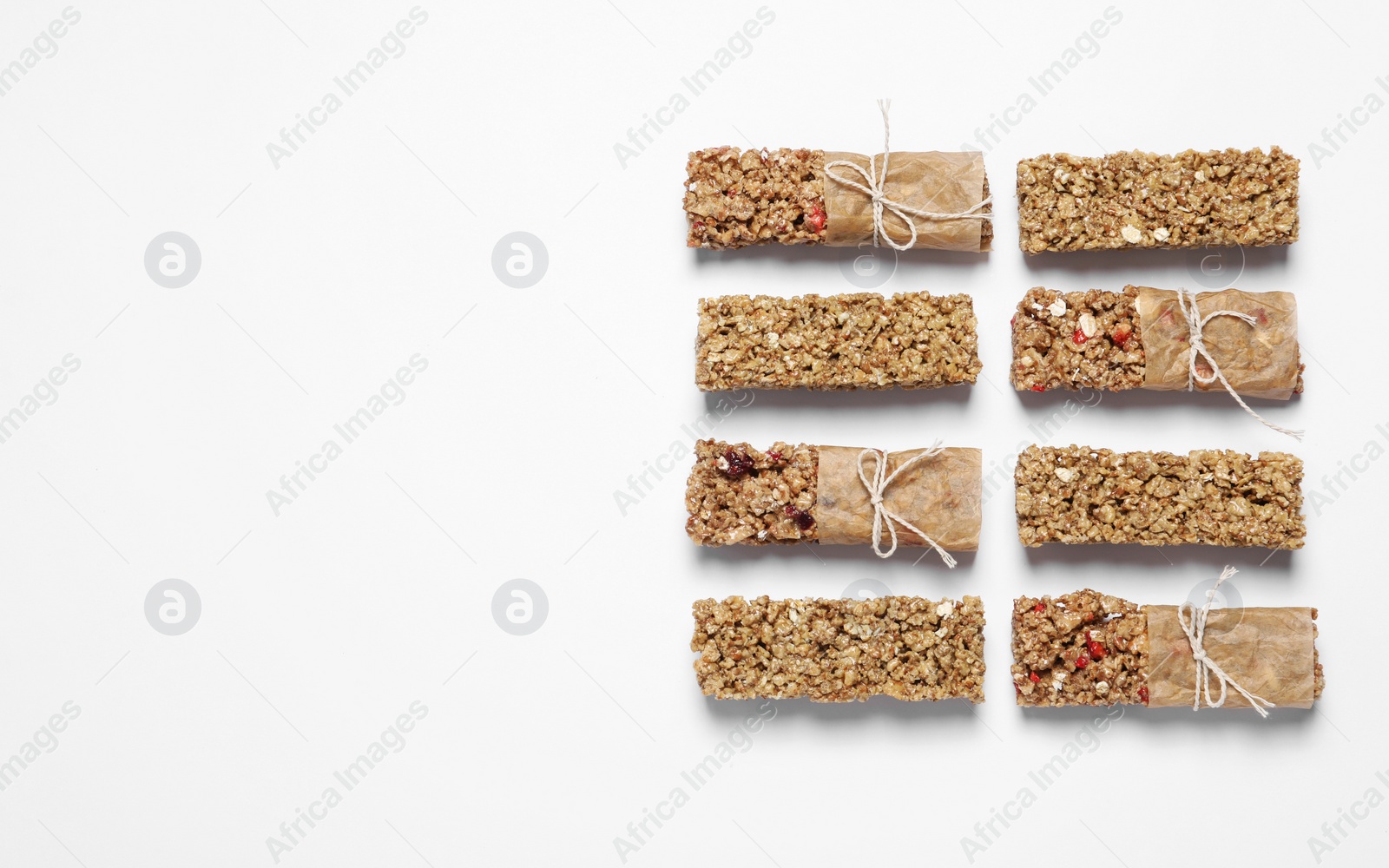 Photo of Different tasty granola bars on white background, flat lay. Space for text
