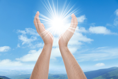 Image of Bright light in hands, closeup. Solar energy concept