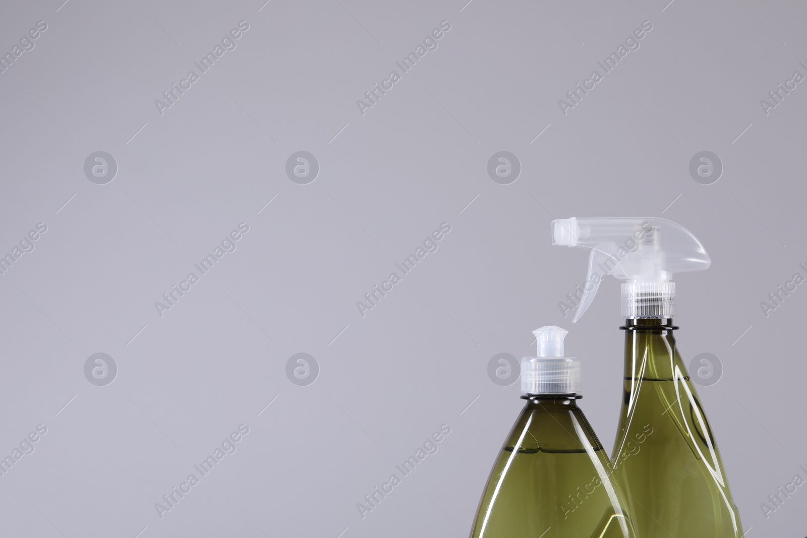 Photo of Bottles of cleaning product on light background, closeup. Space for text