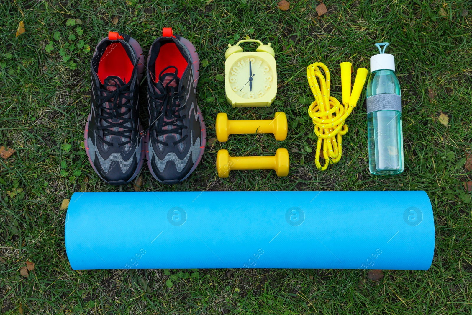 Photo of Set for morning exercise on green grass, flat lay