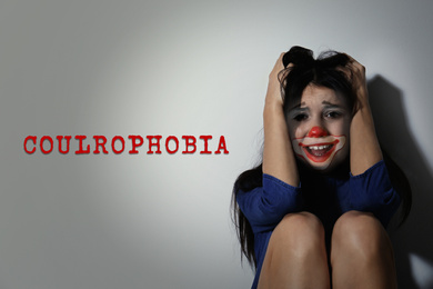 Image of Coulrophobia concept. Double exposure of scared woman and clown