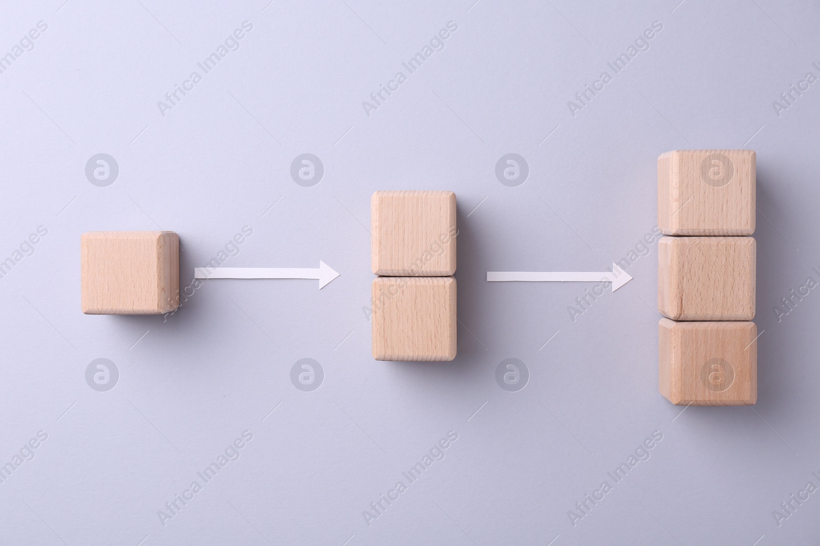 Photo of Business process organization and optimization. Scheme with wooden cubes and arrows on light grey background, top view