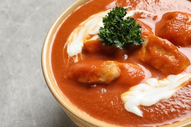 Photo of Bowl of delicious butter chicken on table, closeup. Traditional indian Murgh Makhani