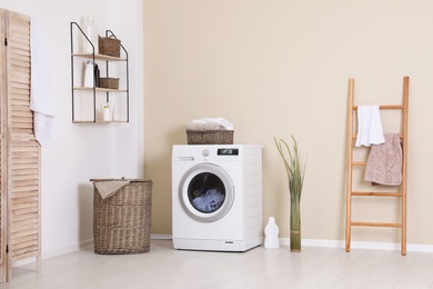 Photo of Laundry room interior with washing machine near wall