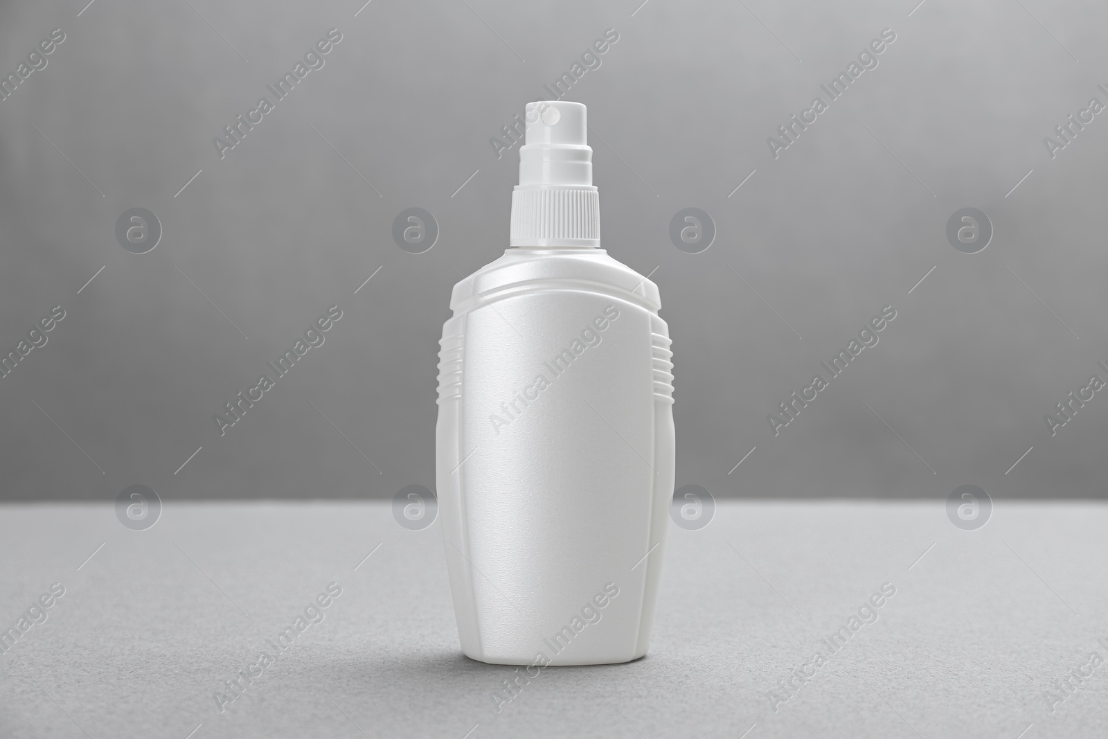 Photo of Bottle with insect repellent spray on grey background