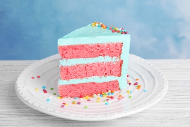 Photo of Slice of fresh delicious birthday cake on table against color background