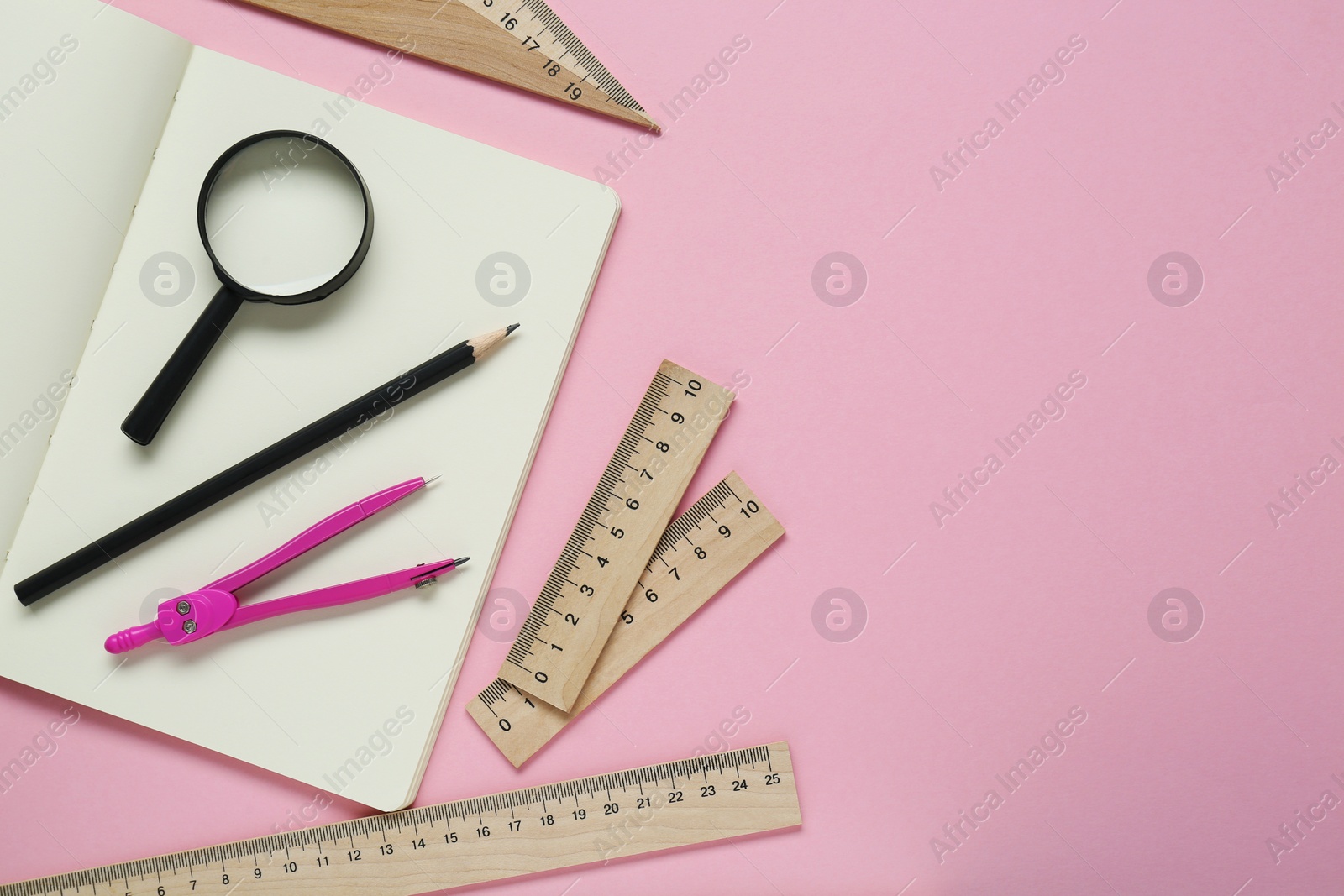 Photo of Different rulers, pencil, compass and magnifying glass on pink background, flat lay. Space for text