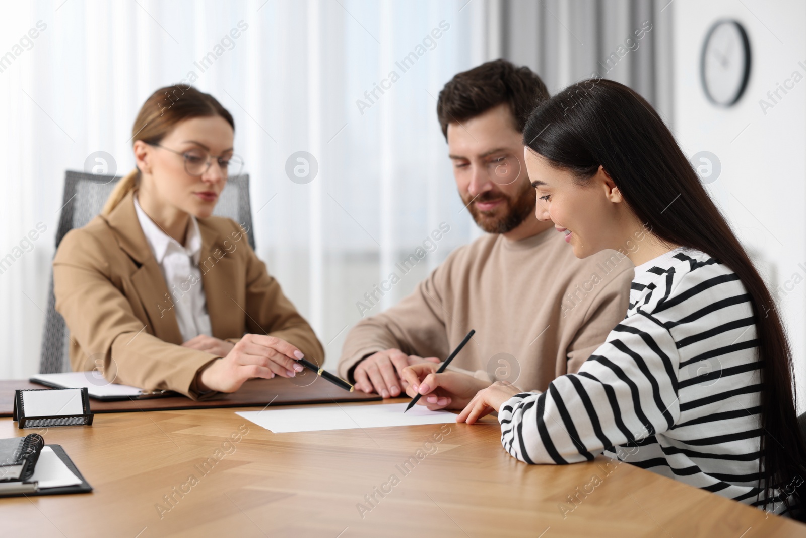 Photo of Couple signing document while having meeting with lawyer in office, selective focus