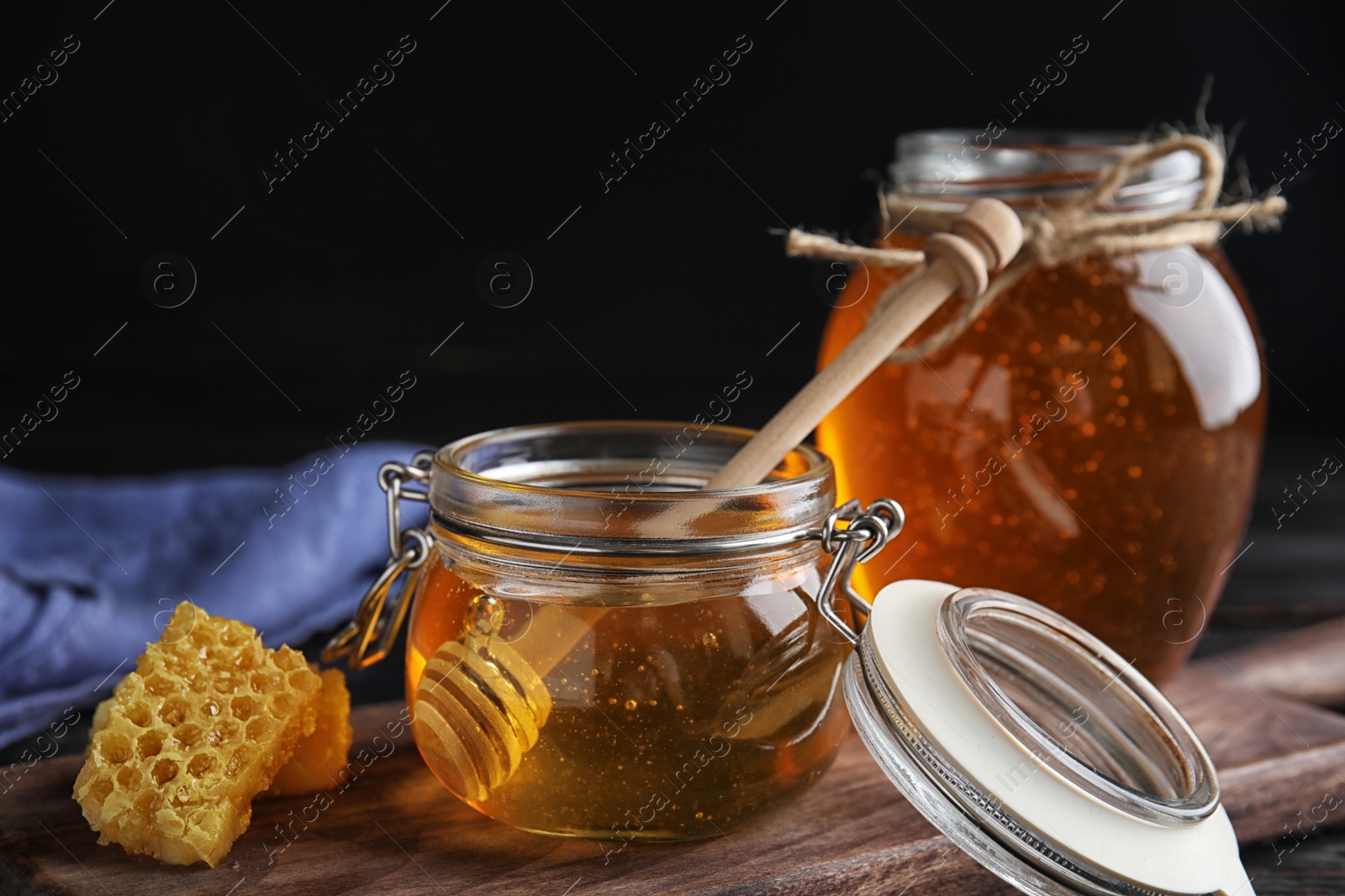 Photo of Jar of sweet honey on wooden board