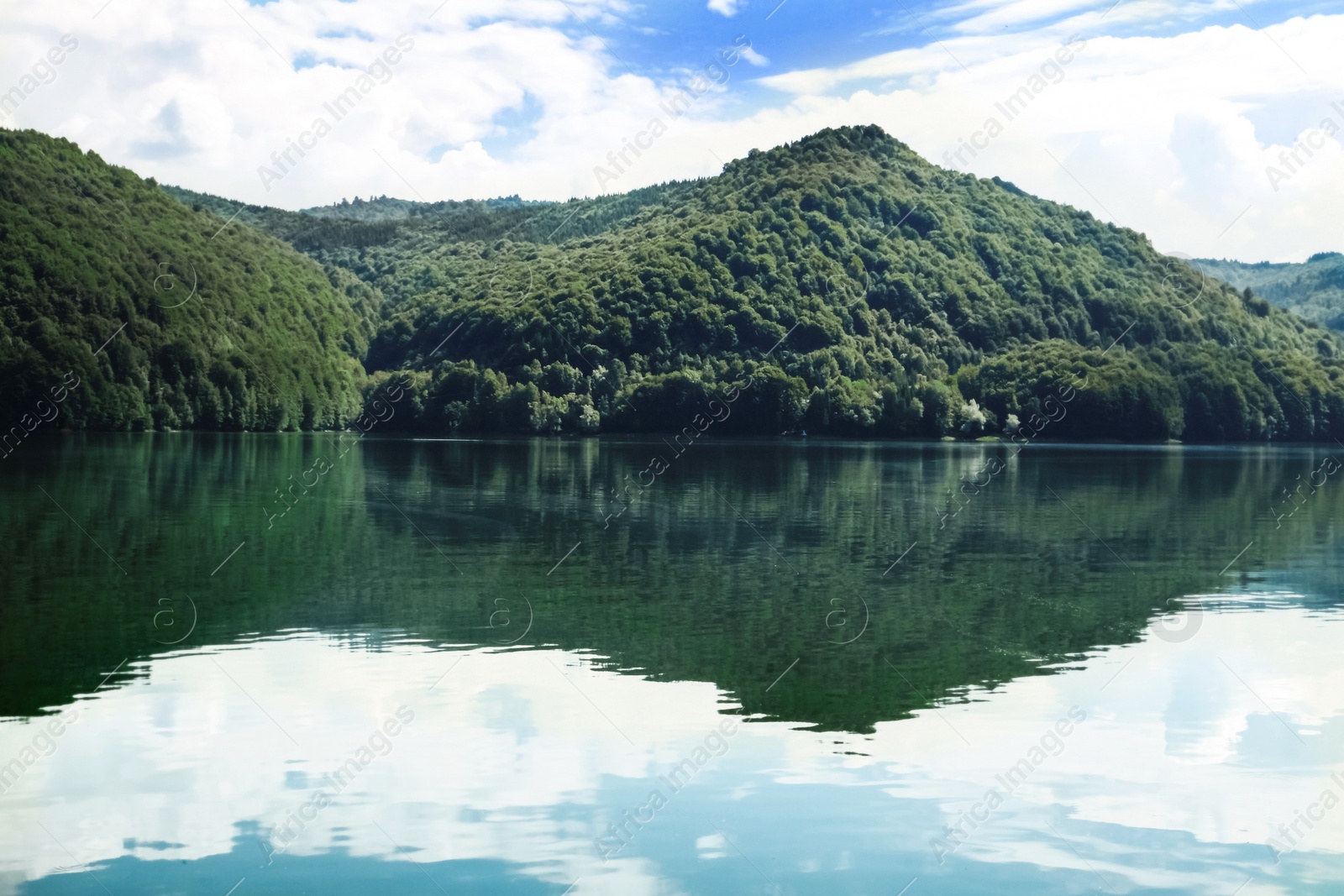 Photo of Picturesque view of beautiful lake surrounded by mountains on sunny day