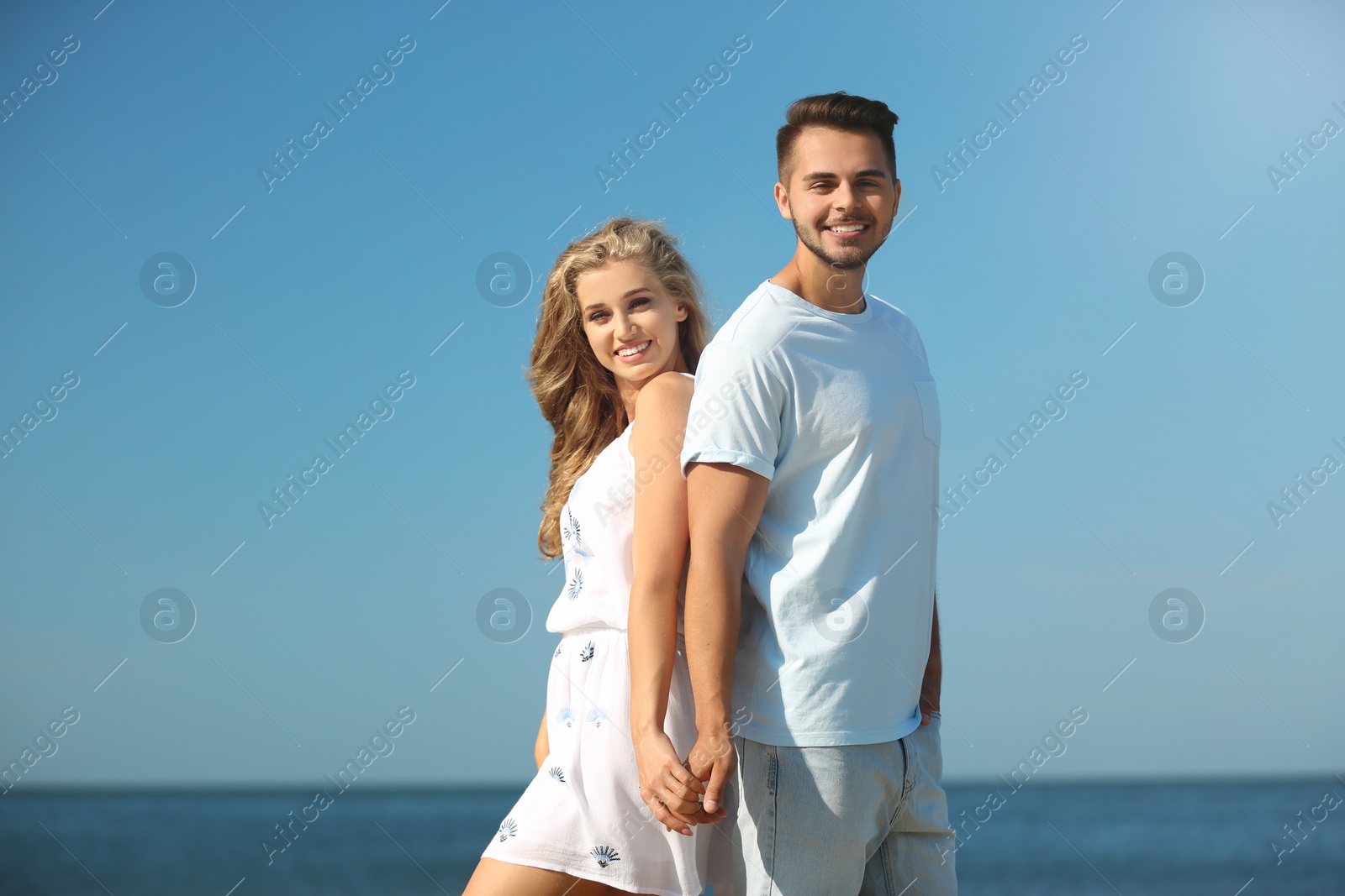 Photo of Happy young couple at beach on sunny day