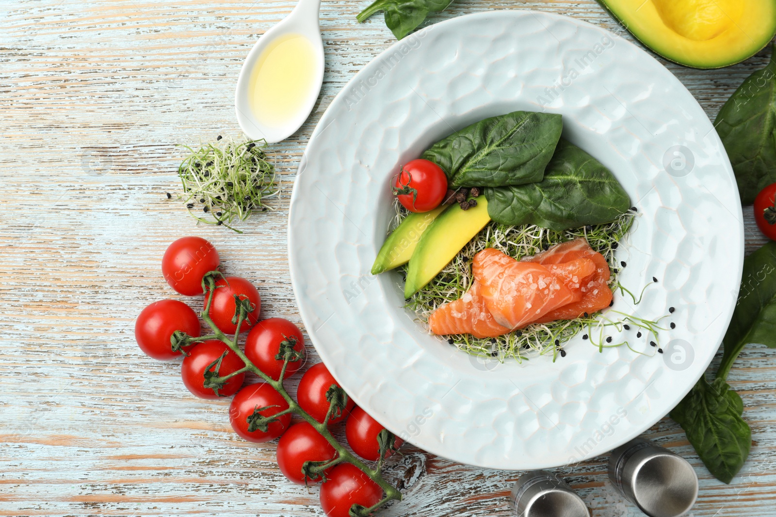 Photo of Delicious salmon with spinach served on light wooden table, flat lay