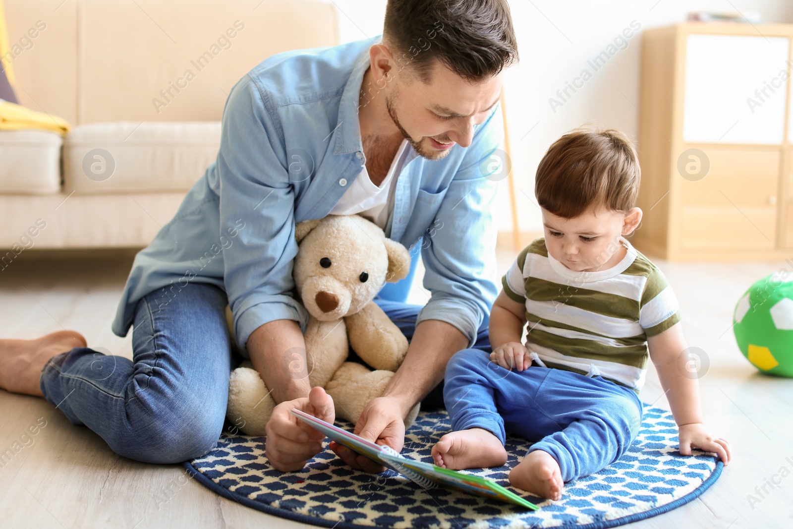 Photo of Dad and his son reading book at home