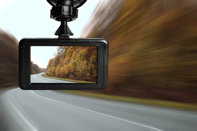 Image of Modern dashboard camera mounted in car, view of road during driving