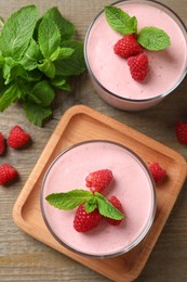 Photo of Delicious raspberry mousse with mint on wooden table, flat lay