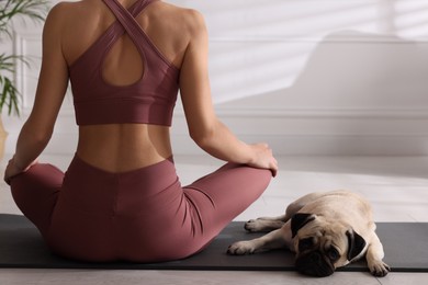 Photo of Woman with dog practicing yoga at home, closeup