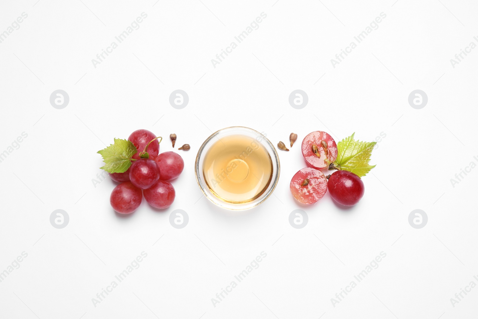 Photo of Composition with bowl of natural grape seed oil on white background, top view. Organic cosmetic