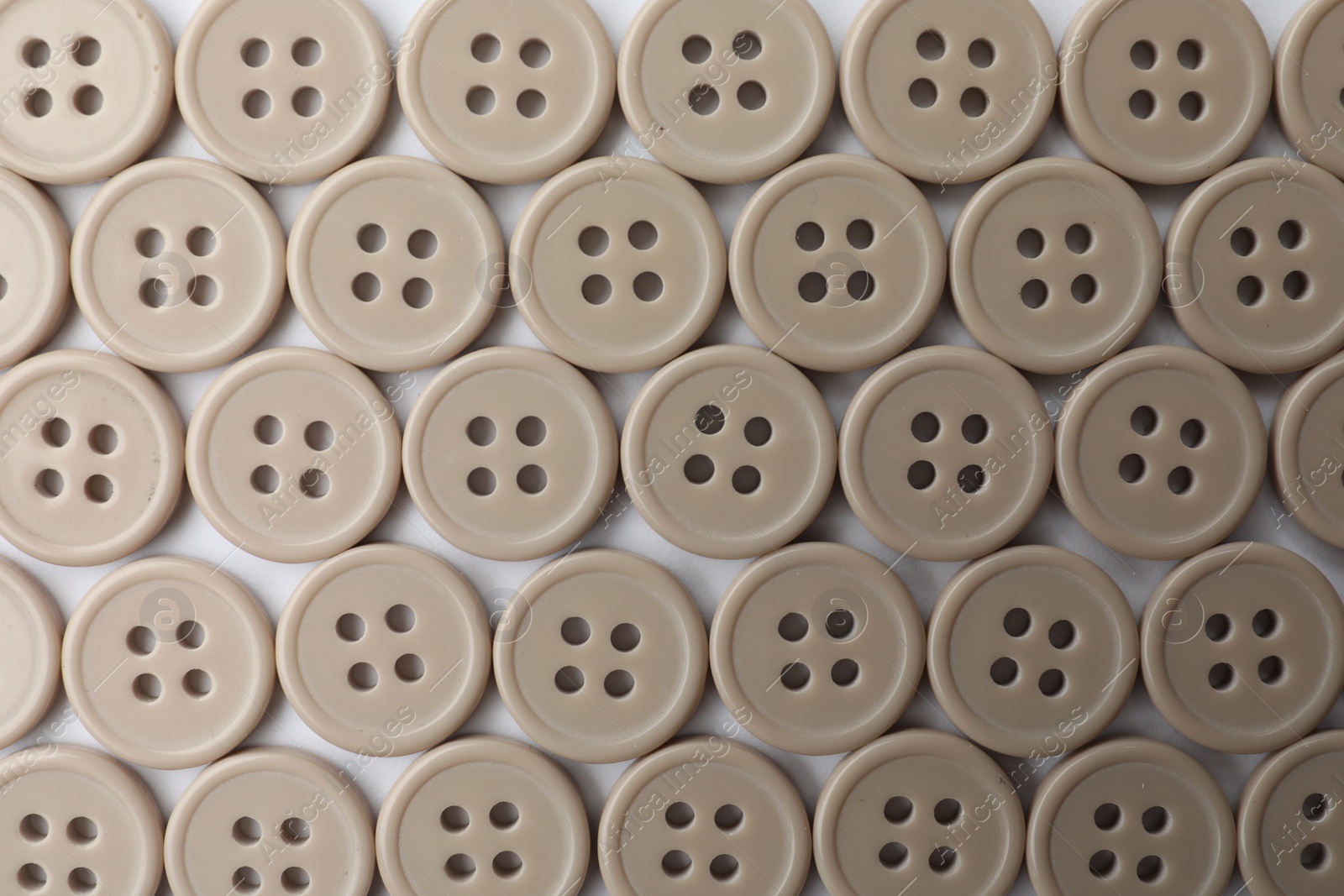 Photo of Many plastic sewing buttons on white background, top view