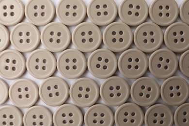 Photo of Many plastic sewing buttons on white background, top view