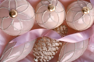 Set of beautiful Christmas baubles and ribbon on pink paper, flat lay