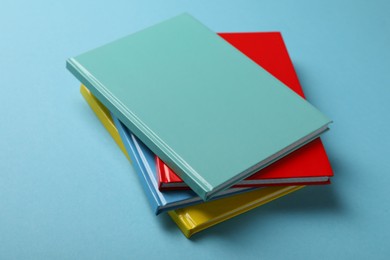 Photo of New colorful planners on light blue background