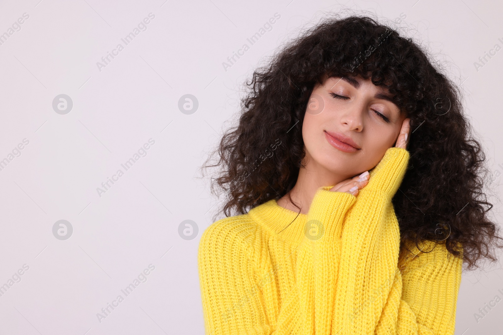 Photo of Young woman in stylish yellow sweater on white background, space for text