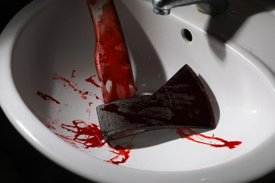 Axe with blood in sink, above view