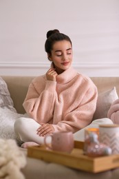 Photo of Beautiful young woman relaxing at home. Cozy atmosphere
