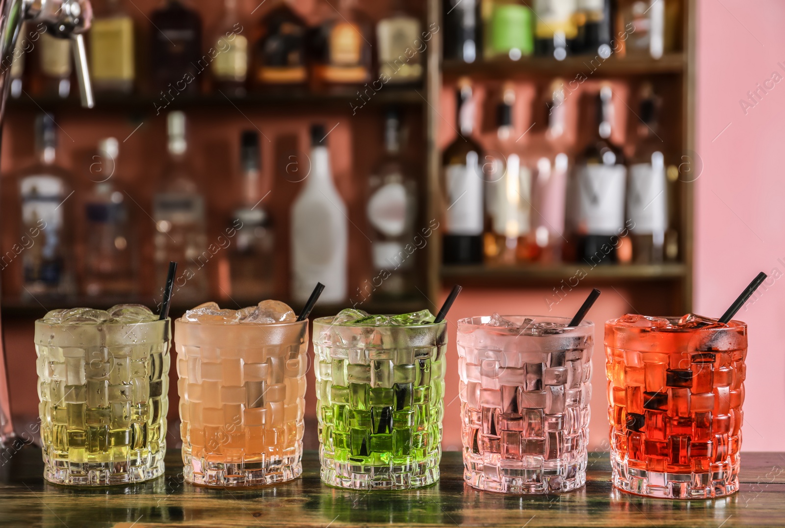 Photo of Glasses of delicious cocktails with ice on table