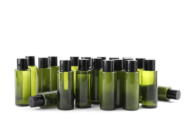 Mini bottles with cosmetic products on white background