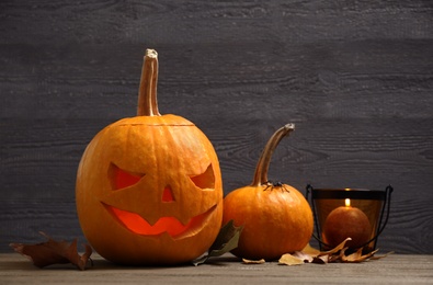 Photo of Spooky Jack pumpkin head lantern on wooden background. Halloween decoration
