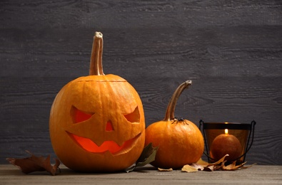 Spooky Jack pumpkin head lantern on wooden background. Halloween decoration