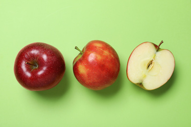 Photo of Tasty red apples on green background, flat lay