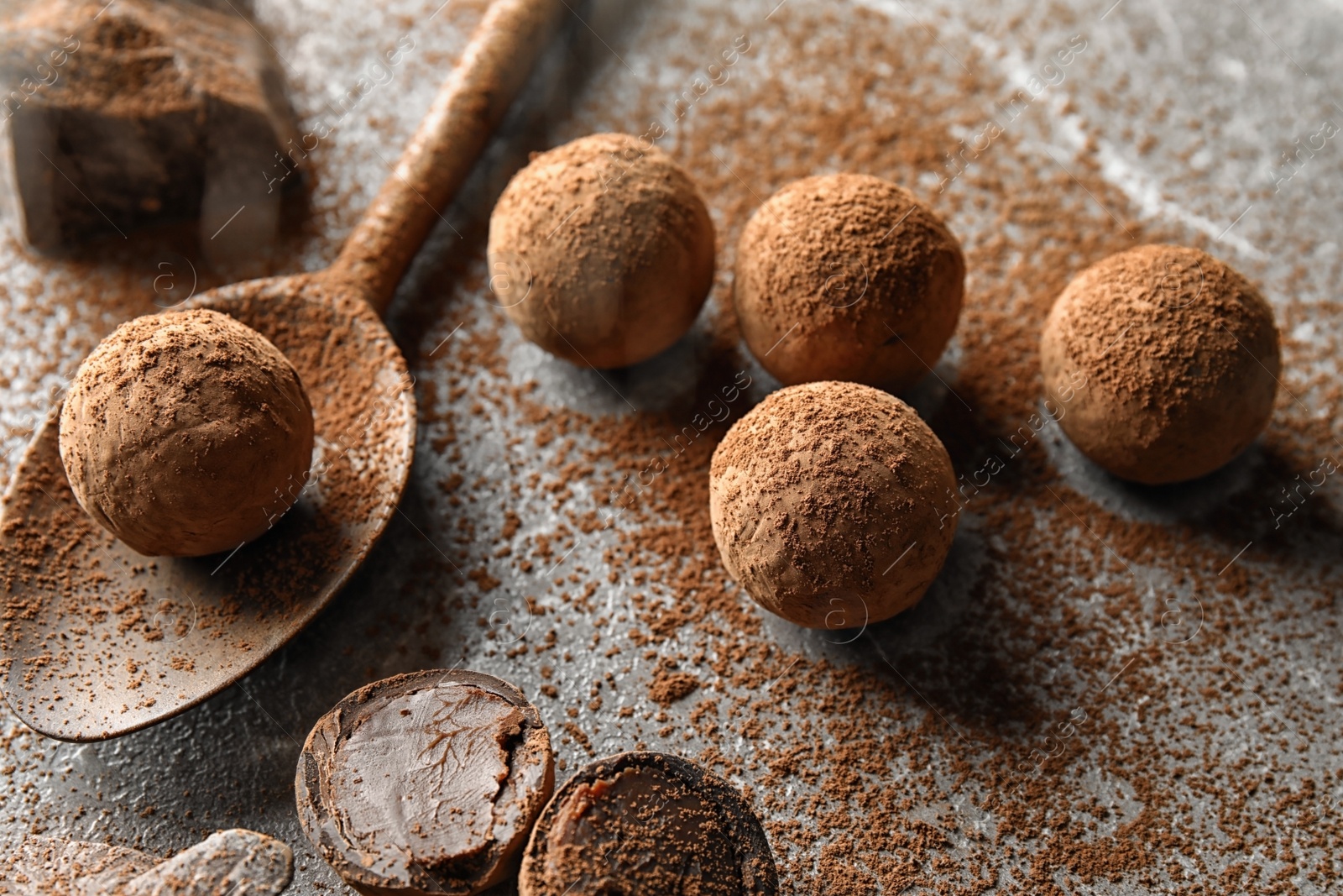 Photo of Composition with spoon and chocolate truffles on grey background