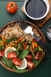 Photo of Tasty fried rice with vegetables served on green wooden table, flat lay